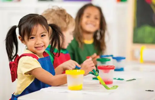 Child painting at table with other kids at Interfaith Child Development Center